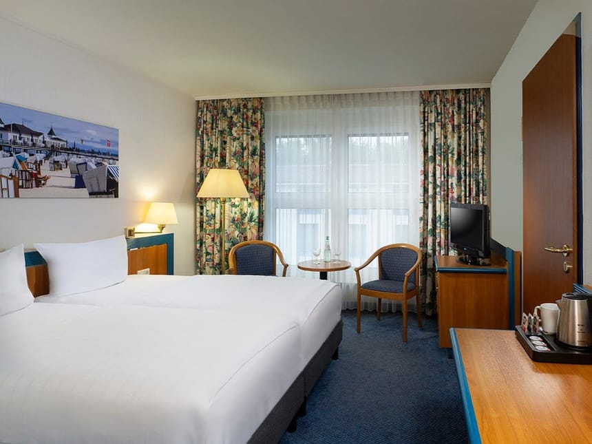 Gemütliches Hotelzimmer mit Doppelbett, Sitzgelegenheit und TV