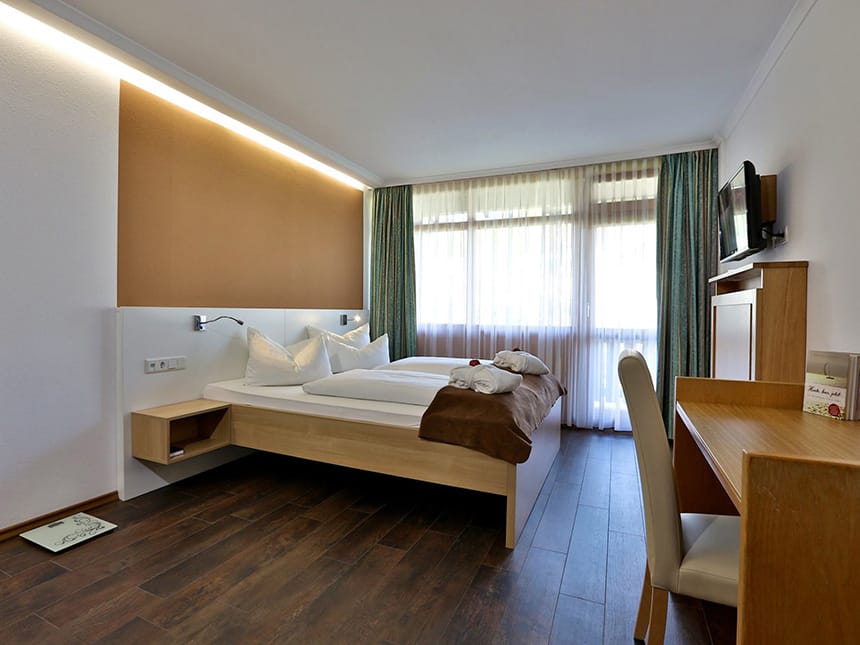 Modernes Doppelzimmer mit TV und Schreibtisch