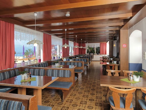 Hotelrestaurant mit verschiedenen Sitzbereichen und Panoramafenstern