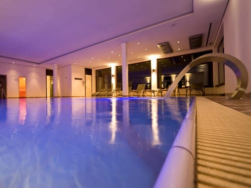 Luxuriöser Innenpool mit entspannender Beleuchtung in einem modernen Wellnessbereich