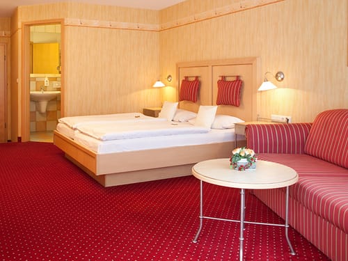 Doppelzimmer mit Bad, Couch und einem Tisch