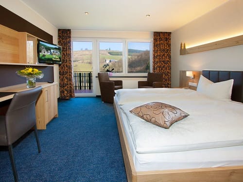 Helles Zimmer mit Sitzecke, Schreibtisch und TV