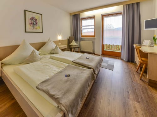 Doppelbett, Stuhl, Schreibtisch und TV im Zimmer