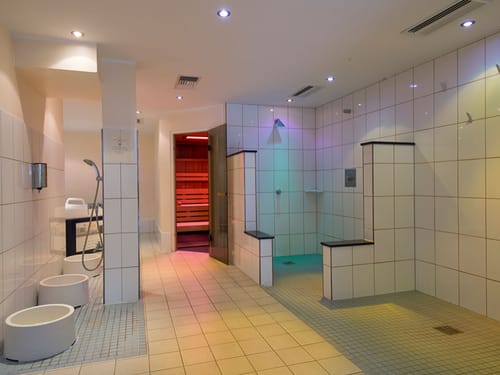 Duschen, Fußbecken und eine Sauna im Wellnessbereich