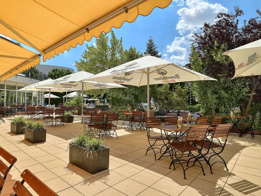 Biergarten mit Tischen, Stühlen und Sonnenschirmen