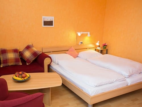 Doppelbett, Couch und Tisch im Doppelzimmer