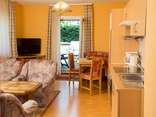 Küchenzeile und Wohnraum in einem mit TV und Zugang Terrasse
