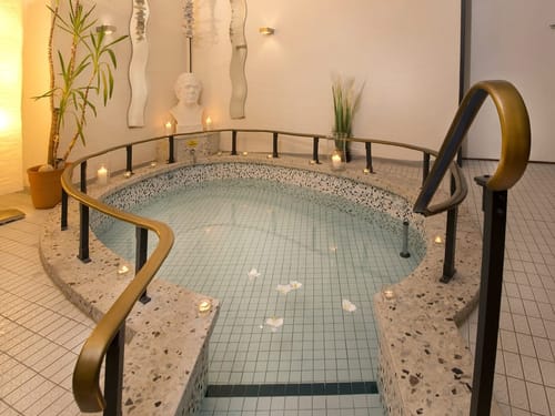 Luxuriöses Spa mit beleuchtetem Tauchbecken und Kerzen