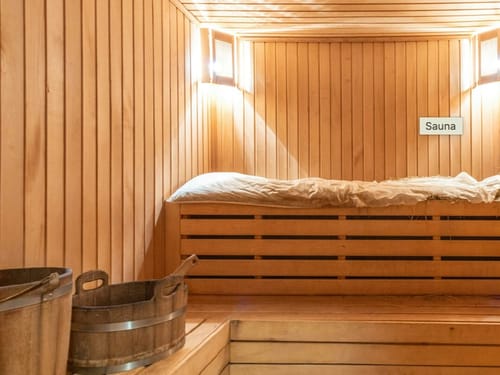 Gemütlicher Sauna-Innenraum mit hölzernen Wänden und Bänken.