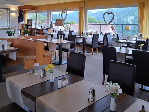 Elegantes Restaurant mit Bergblick, stilvoll dekorierten Tischen und gemütlicher Atmosphäre.