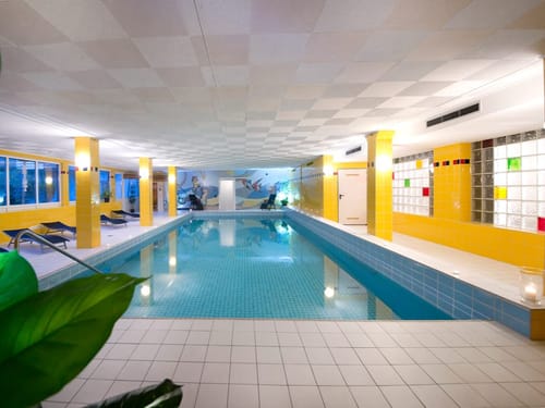 Entspannender Innenpool mit gelben Fliesen und Liegestühlen
