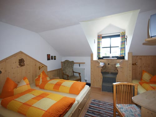 Zimmer mit drei Betten und verschiedene Sitzmöglichkeiten
