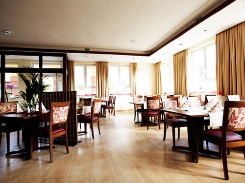 verschieden eingedeckte Tischgruppen im Hotelrestaurant