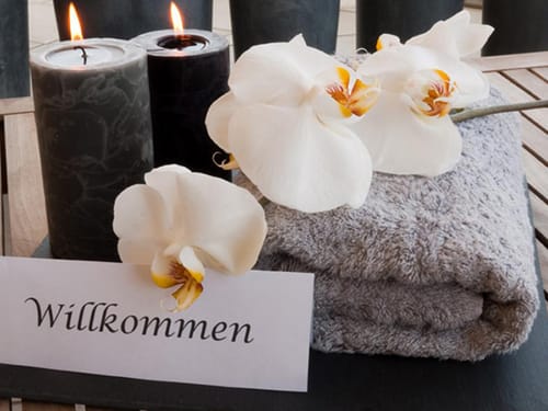 Badetuch, Kerzen und Blumendeko im Wellnessbereich