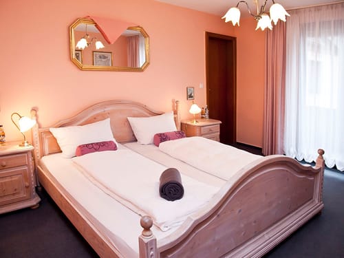 einfaches Doppelzimmer mit Doppelbett und Nachttisch