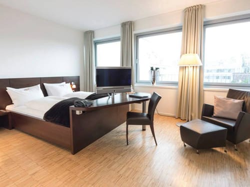 Großes Zimmer mit TV, einem Sessel und einem Stuhl