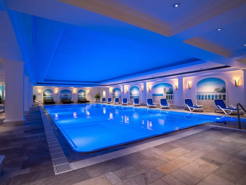 Wellnessbereich mit großem Pool und Relaxliegen am Rande
