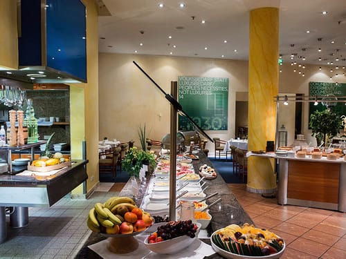 Frühstücksbuffet mit verschiedenen Sorten Obst, Müsli, Wurst, Käse und Brotsorten