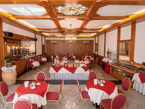 verschieden eingedeckte Tische im Restaurant mit einer großen Auswahl am Frühstücksbuffet