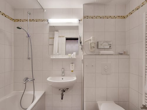 Badbreich mit WC, Duschwanne, Waschbecken und Spiegel