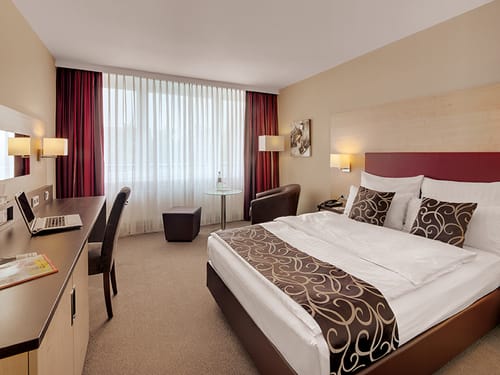 Doppelzimmer Standard mit Boxspringbett, Sessel, Schreibtisch und Stuhl