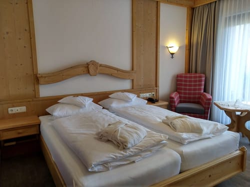 Gemütliches Hotelzimmer mit Doppelbett und rustikaler Holzeinrichtung