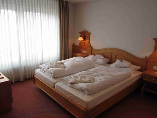 Gemütliches Hotelzimmer mit Doppelbett und Holzinterieur