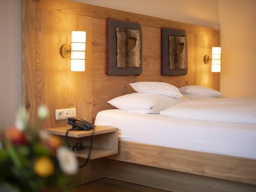 Entdecken Sie unser stilvolles Hotelzimmer mit einem großzügigen Kingsize-Bett, umgeben von eleganten Holzelementen. Perfekt für erholsame Nächte und entspannte Aufenthalte.