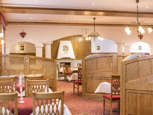 Gemütliches Interieur eines traditionellen bayerischen Restaurants mit Holzmöbeln und stimmungsvoller Beleuchtung.