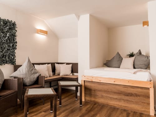 Gemütliche Sitzecke und Tagesbett in modernem Wohnraumdesign mit Holzakzenten.