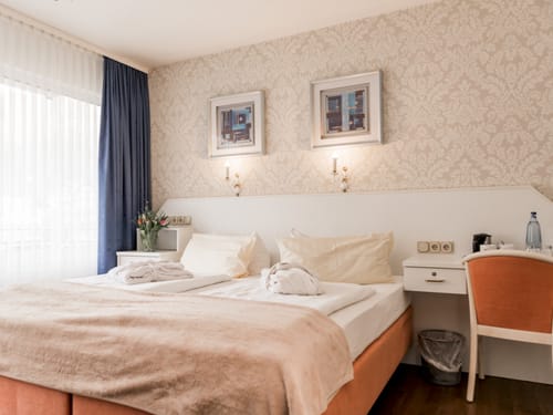 Gemütliches Hotelzimmer mit Doppelbett und eleganter Einrichtung