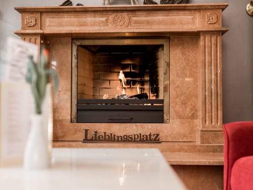 Gemütlicher Kamin mit brennendem Feuer im Wohnzimmer.