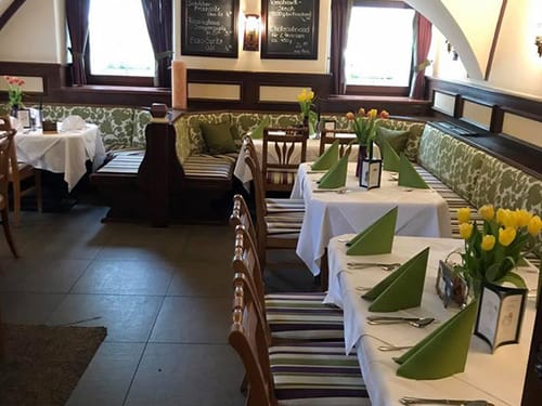 weiß grün eingedeckte Tische im Hotel Restaurant