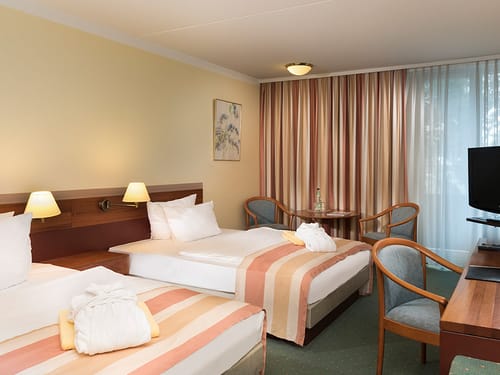 Standardzimmer mit Twinbett Stühlen und Tisch