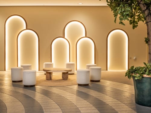 Moderne Lounge mit beleuchteten Bögen und stilvollen Möbeln