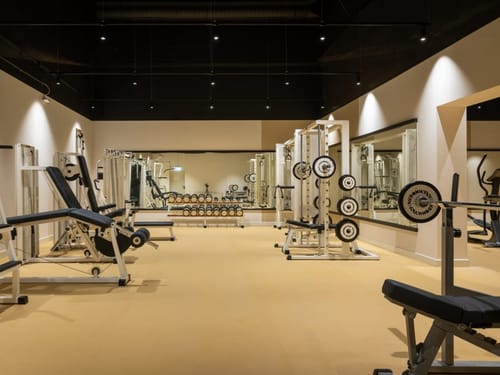 Moderner Fitnessraum mit Gewichten und Trainingsgeräten