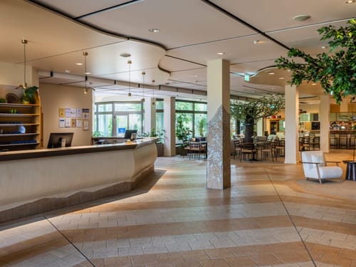 Helles und modernes Hotellobby-Interieur mit Rezeption und Sitzbereich.