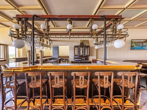 Innenansicht einer stilvollen, leeren Bar mit Holzstühlen und klassischem Interieur.