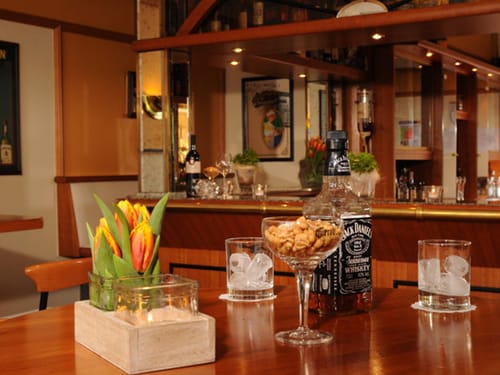 Hotelbar mit einer Flasche Whiskey, Erdnüssen und Gläser gefüllt mit Eiswürfeln