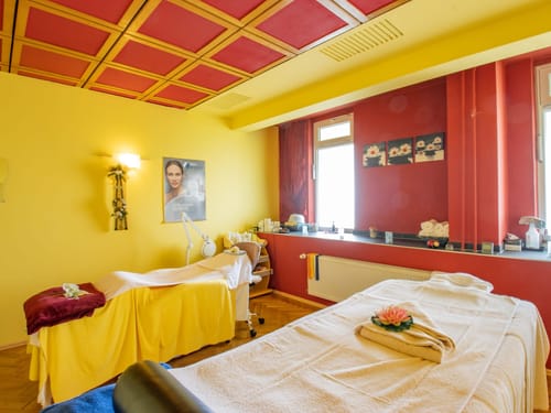 Entspannender Massageraum mit gelben und roten Waenden