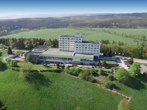 Luftaufnahme eines Hotels inmitten einer grünen Landschaft und Waldgebieten