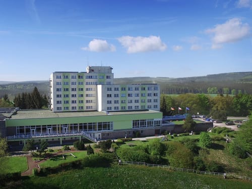 Modernes Hotelgebäude in grüner Landschaft an einem sonnigen Tag