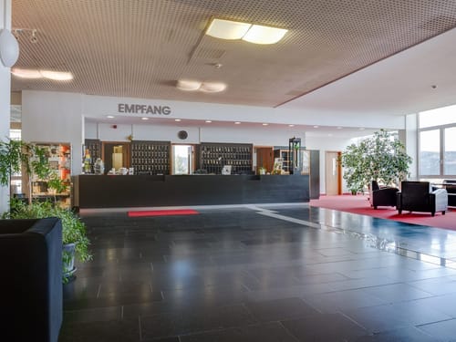 Hotel-Lobby mit Empfangsbereich und Sitzgelegenheiten