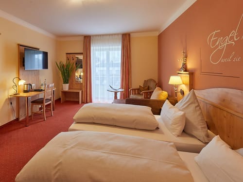 Gemütliches Hotelzimmer mit Doppelbett, Schreibtisch und warmen Farbtönen.