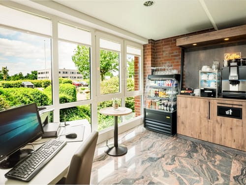 Einladende Hotellobby mit Coffee-Corner, Kaltgetränkeauswahl und Business-PC