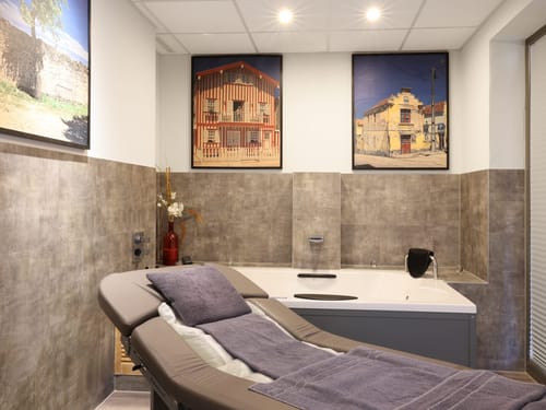 Behandlungsraum mit Massageliege und Hydro-Badewanne