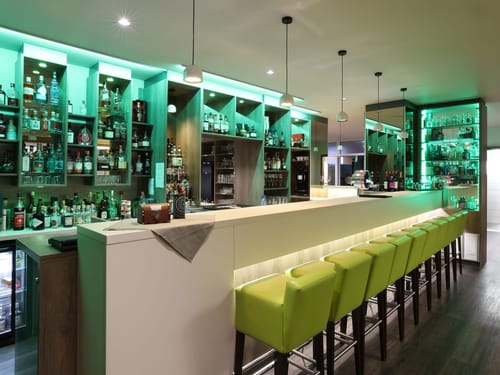 Stilvolle Hotelbar mit grünem Ambiente und exklusiver Spirituosenauswahl