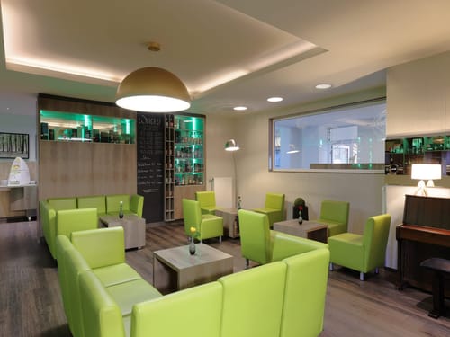 Lounge mit grünen Sesseln und Whisky-Bar