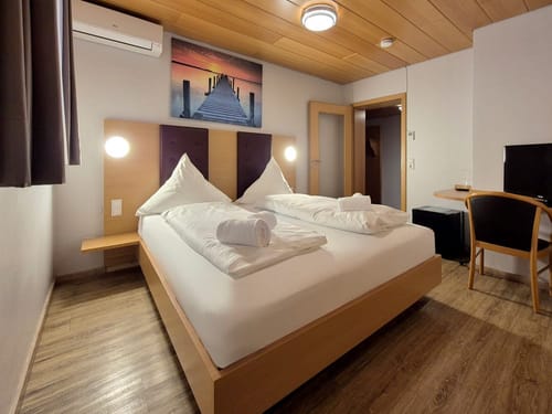 Doppelzimmer mit Doppelbett, Schreibtisch, TV und Stuhl