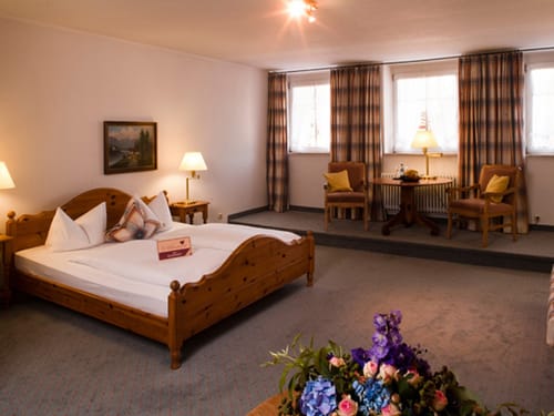 geräumiges Doppelzimmer mit Sitzecke, Doppelbett und Nachttisch